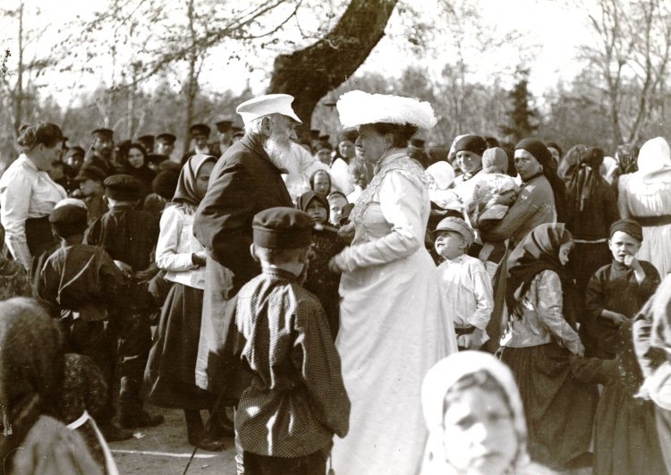 Л.Н. и С.А. Толстые и Александра Львовна (слева) среди крестьян деревни Ясная Поляна в Троицын день. Автор: Тапсель Т. Ясная Поляна. 1909 15,9х22,2.